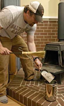 A man cleans out his wood stove